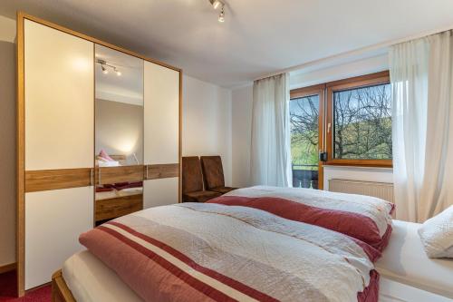 a bedroom with a large bed and a window at Fewo Schwarzwald - Haus Sommerberg in Baiersbronn