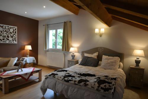 a bedroom with a bed and a couch and a window at La Chambre De Jaxel in Saint-Martin-en-Vercors