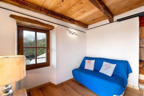 a blue couch in a room with a window at La torretta di Mozzola in Oggebio