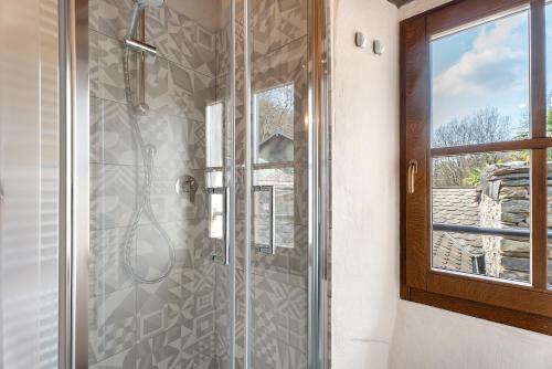 a bathroom with a glass shower with a window at La torretta di Mozzola in Oggebio