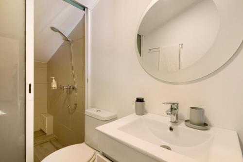 a white bathroom with a sink and a mirror at Casa Amarela in Caniço
