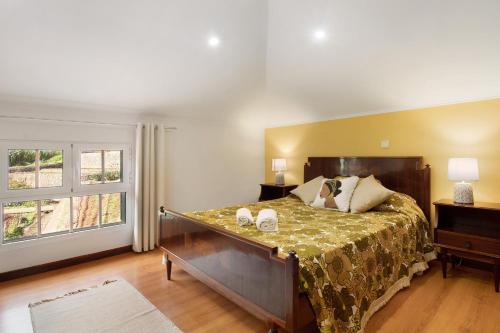 a bedroom with a large bed and a window at Casa Amarela in Caniço