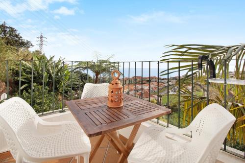 a wooden table and chairs on a balcony at Casa Amarela in Caniço