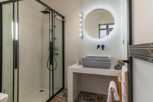 a bathroom with a shower and a sink and a mirror at A The Country House in Tinos