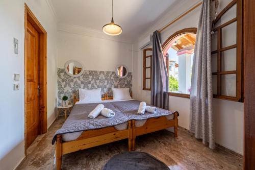 a bedroom with a bed and a window at Nana's House Holidays Greece in Dragotiná