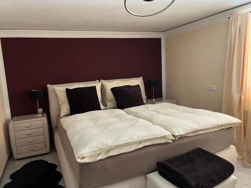 a bedroom with a bed with white sheets and black pillows at Seerhaus in Mosern