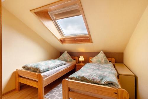 two twin beds in a room with a skylight at Ferienwohnung Triska in Balve