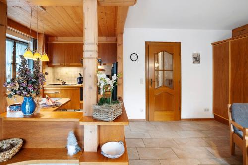a kitchen with wooden cabinets and a table with flowers at Ferienhaus Werdenfels in Mittenwald