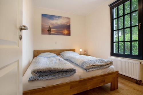 a bedroom with a bed with two pillows on it at Haffmöwe Ferienhaus 96 in Mönkebude