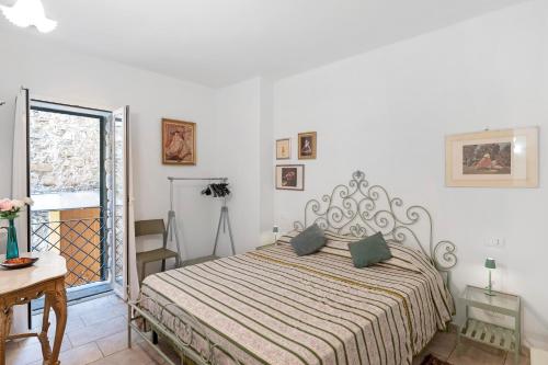 a bedroom with a bed and a table and a window at Villa sole e mare in Cipressa
