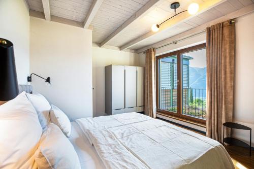 a bedroom with a bed and a large window at Kraidlhof Designapartment Veronika in Cortaccia