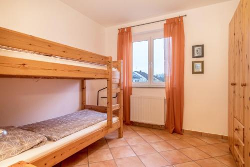 a bedroom with two bunk beds and a window at Haus Sonnenseite Wohnung Säntis in Wasserburg