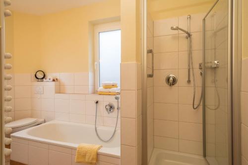 a bathroom with a bath tub and a shower at Haus Sonnenseite Wohnung Säntis in Wasserburg