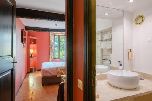 a bathroom with a tub and a bedroom with a bed at Le Grimaldi in Cagnes-sur-Mer