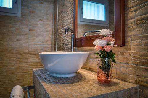 a bathroom with a bowl sink and flowers in a vase at Casa Isabel in Calonge