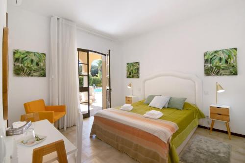 a bedroom with a bed and a table and a chair at V4 Galeão Vilamoura in Vilamoura
