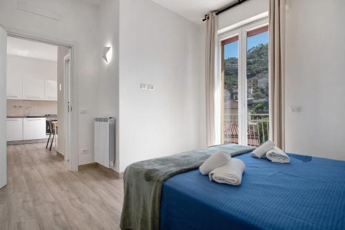 a white bedroom with a blue bed with two pillows at Moneglia Mare in Moneglia