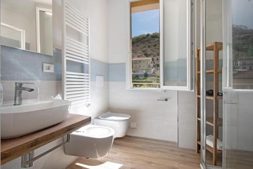 a bathroom with a sink and a toilet and a window at Moneglia Mare in Moneglia