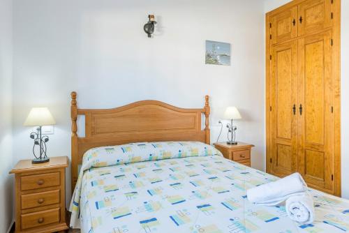a bedroom with a bed and two night stands and two lamps at Bungalows La Aceitera - Apartamento 2 in Zahora
