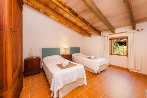 a bedroom with two beds and a window at Finca Ses Coves in Petra