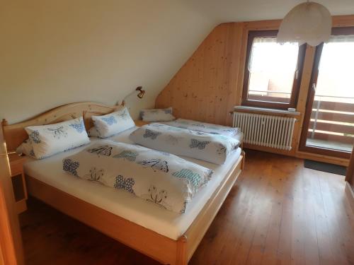 a bedroom with two beds and two windows at Haus Fehrenbach in Sankt Märgen