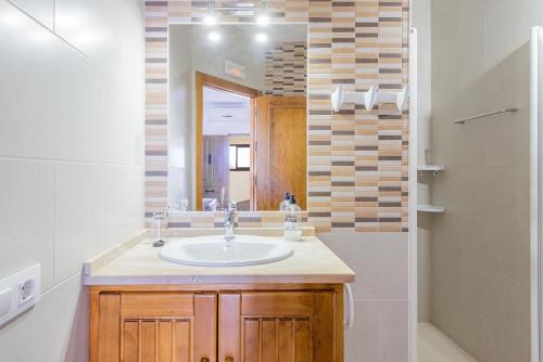 a bathroom with a sink and a mirror and a shower at Bungalows La Aceitera - Apartamento 2 in Zahora