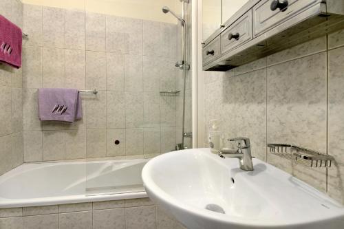 a bathroom with a sink and a bath tub at Palheiro Residence Familiar 1 in Funchal