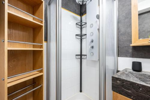 a shower in a bathroom with wooden cabinets at victorsun2 in La Clusaz