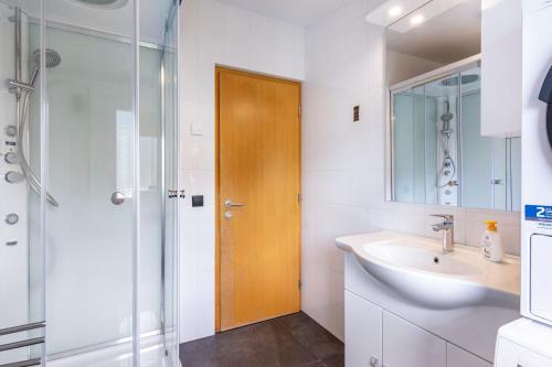 a bathroom with a sink and a wooden door at Ferienwohnung Hans in Prato allo Stelvio
