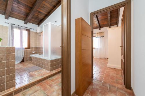 a bathroom with a walk in shower and a tub at Villa Rossu in Nuxis