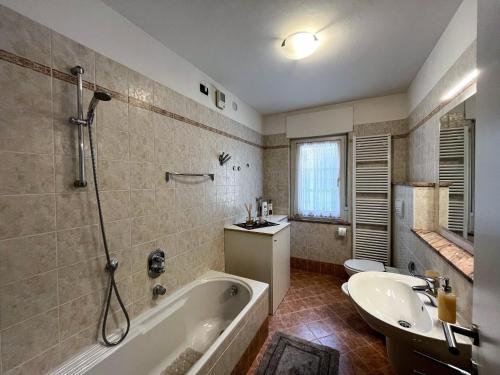 a bathroom with a tub and a sink at Appartamento Cornon in Tesero