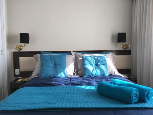Una cama con sábanas azules y almohadas en un dormitorio en Apartamento confortável - Jd Paulista, en São Paulo