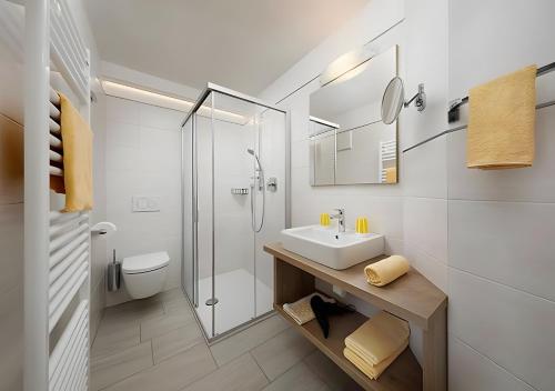 a white bathroom with a sink and a shower at Wieser in Schenna
