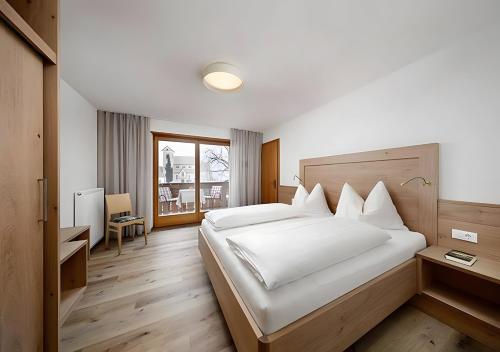a bedroom with a large white bed with white pillows at Wieser in Schenna