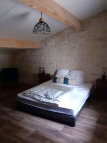 a large bed in a room with a ceiling at Domaine du Val Bruant in Arc-en-Barrois