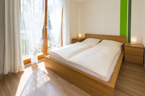 a bed in a bedroom with a large window at Ferienhaus Am Sedelbach in Deggenhausertal