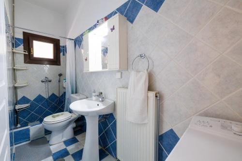 a blue and white bathroom with a sink and a toilet at Breathing Apartment in Virós
