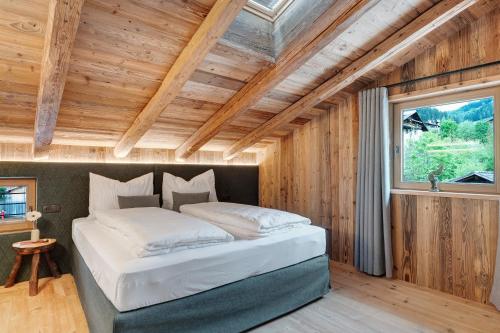 a bed in a room with a wooden ceiling at Wellness Chalet Samer in Sarntal