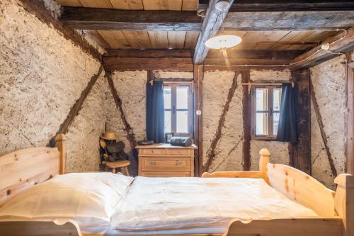 a bedroom with a bed and a dresser and windows at Tannhäuser Mountain Chalet in Predoi