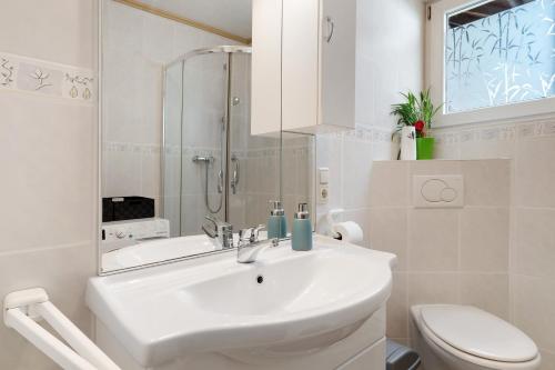 a white bathroom with a sink and a toilet at Ferienwohnung Am Brunnen in Durbach