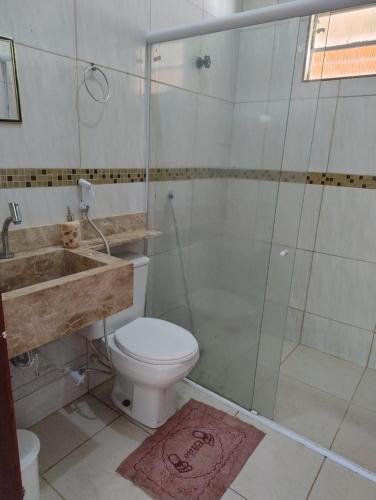 a bathroom with a toilet and a shower and a sink at Casa da Mari in Caucaia