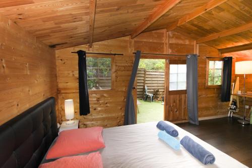 a bedroom with a bed in a log cabin at Le Chalet De La Plage in Coti-Chiavari