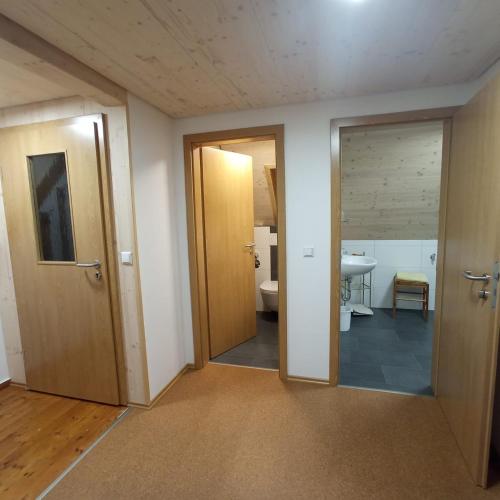 an empty room with two doors and a bathroom at Haus Fehrenbach in Sankt Märgen