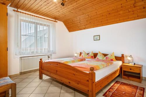 a bedroom with a wooden bed and a window at Ferienhaus Behler in Kressbronn am Bodensee