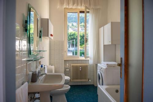 a bathroom with two sinks and a toilet and a window at Verbania Panorama Lago in Verbania