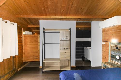 Una habitación con nevera y paredes de madera. en Le Chalet De La Plage, en Coti-Chiavari