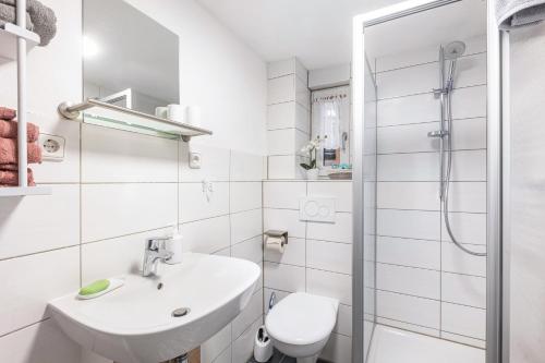 a white bathroom with a sink and a toilet at Ferienhaus Feußner in Lauterbach