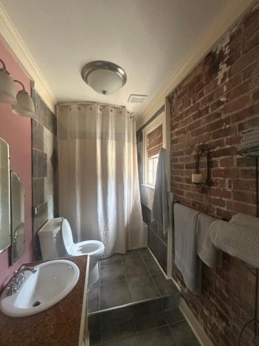 a bathroom with a sink and a brick wall at Town Square Charm Century Old in Lewisville