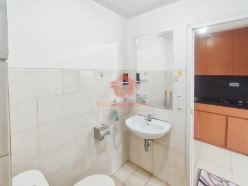 a bathroom with a toilet and a sink at Cozy 2BR Bintaro Park View Pool in Jakarta
