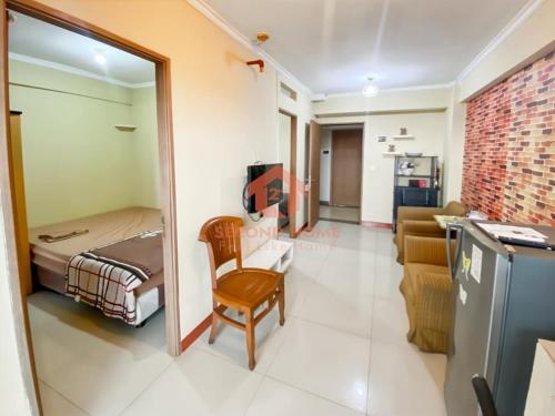 a room with a bed and a chair in a room at Cozy 2BR Bintaro Park View Pool in Jakarta